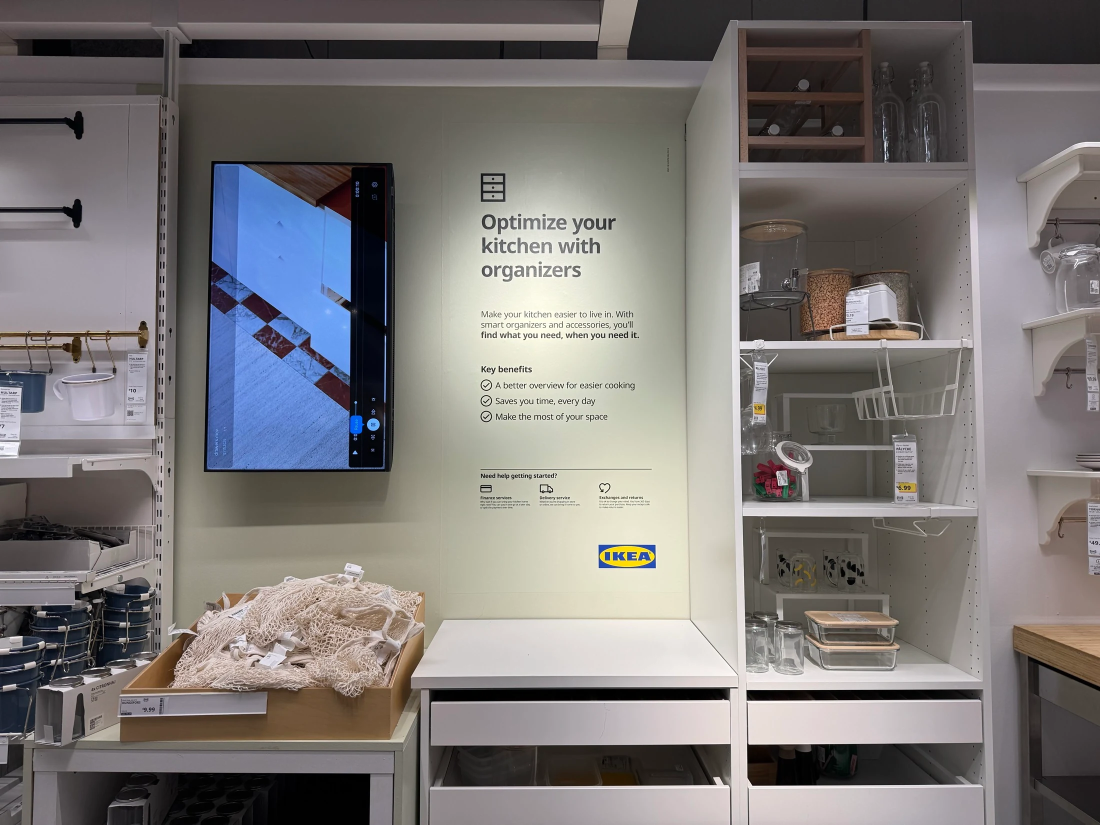 Kitchen organizers display with a printed information panel whose pale background is matched to the surrounding wall.