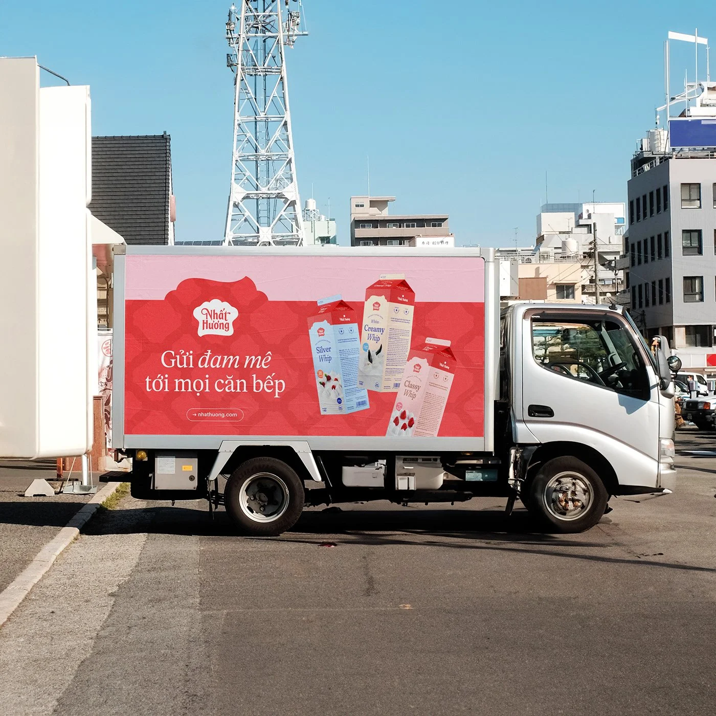 Fleet livery concept: a delivery truck wrapped in the sweet-red brand with packaging photography and the slogan in Vietnamese